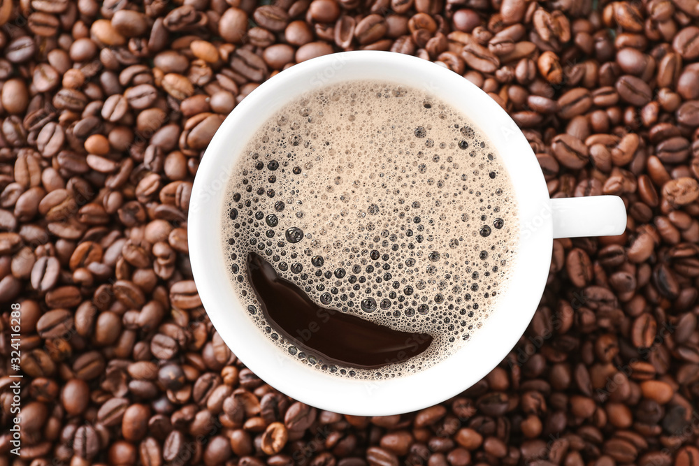Fototapeta premium Cup of hot coffee on beans