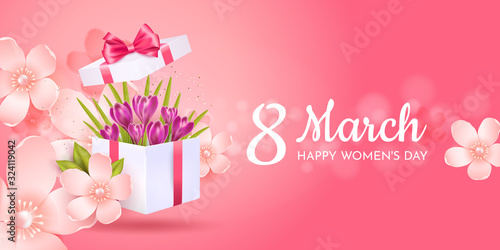 Greeting card for International Women's Day (March 8). Open gift box with purple crocuses in apple blossoms on a pink background.