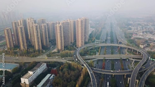 Huge leveled up elevated road traffic junction next to the tall skyscrapers multi-storey residential buildings. Eastern part of Chengdu, Chenghua district. High level air pollution, unhealthy AQI. photo