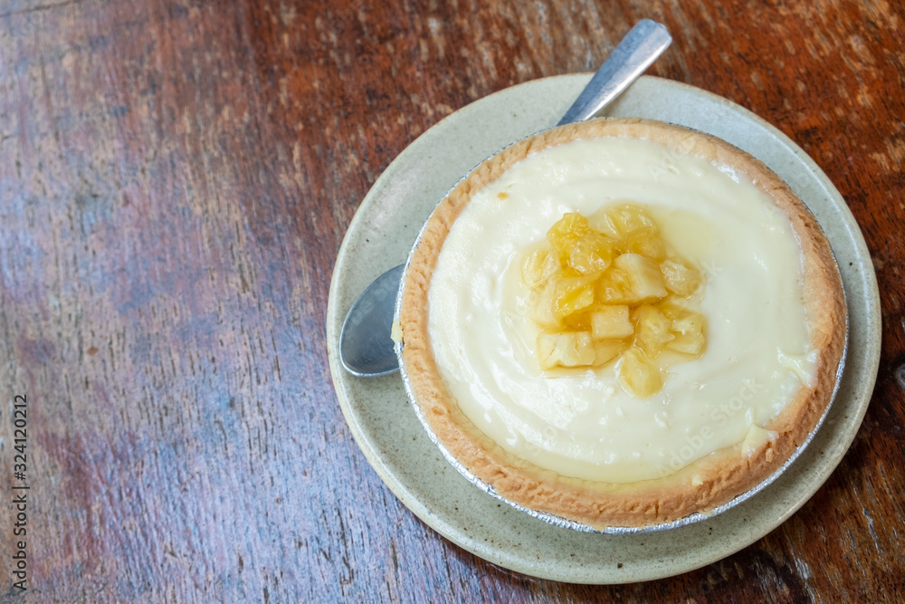 A piece of homemade Pineapple tart on wooden table. Tarts is a baked dish and usually fruit-based, sometimes with custard. A piece of homemade Pineapple tart on wooden table. Tarts is a baked dish and usually fruit-based, sometimes with custard.