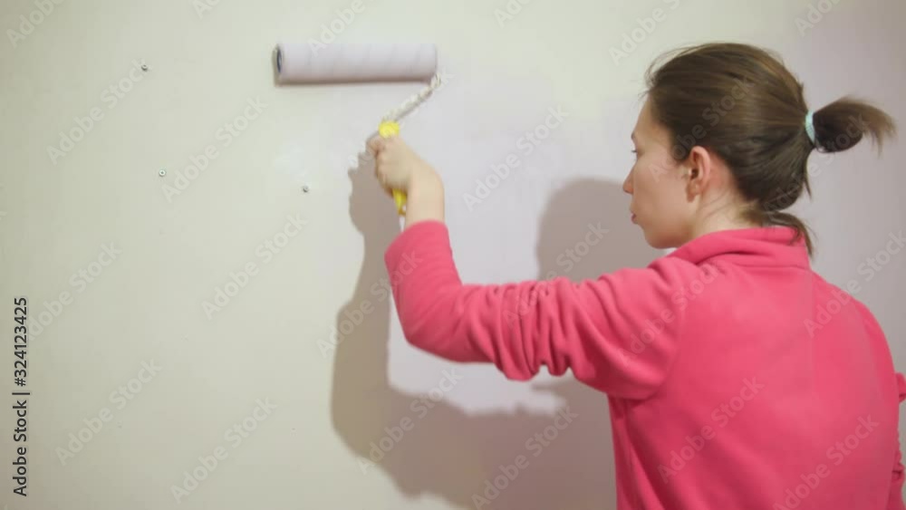 Happy beautiful young woman doing wall painting Happy beautiful young woman doing wall painting