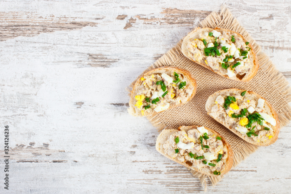 Baguette or sandwiches with mackerel or tuna fish paste, copy space for text on board Baguette or sandwiches with mackerel or tuna fish paste, copy space for text on board