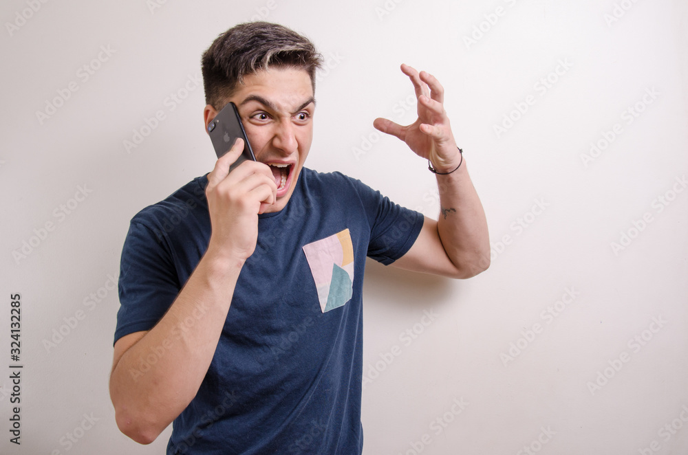 Angry young man screaming in a phone call Angry young man screaming in a phone call