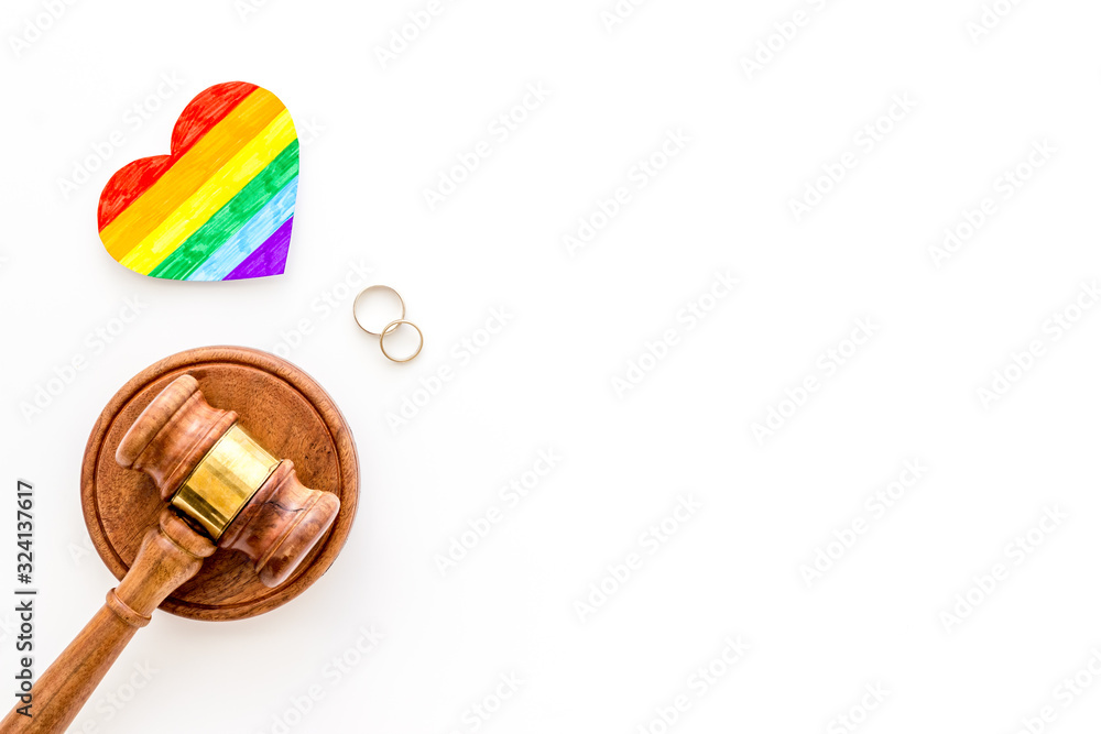 LGBT divorce. Rainbow heart near rings and judge gavel on white background top-down copy space LGBT divorce. Rainbow heart near rings and judge gavel on white background top-down copy space