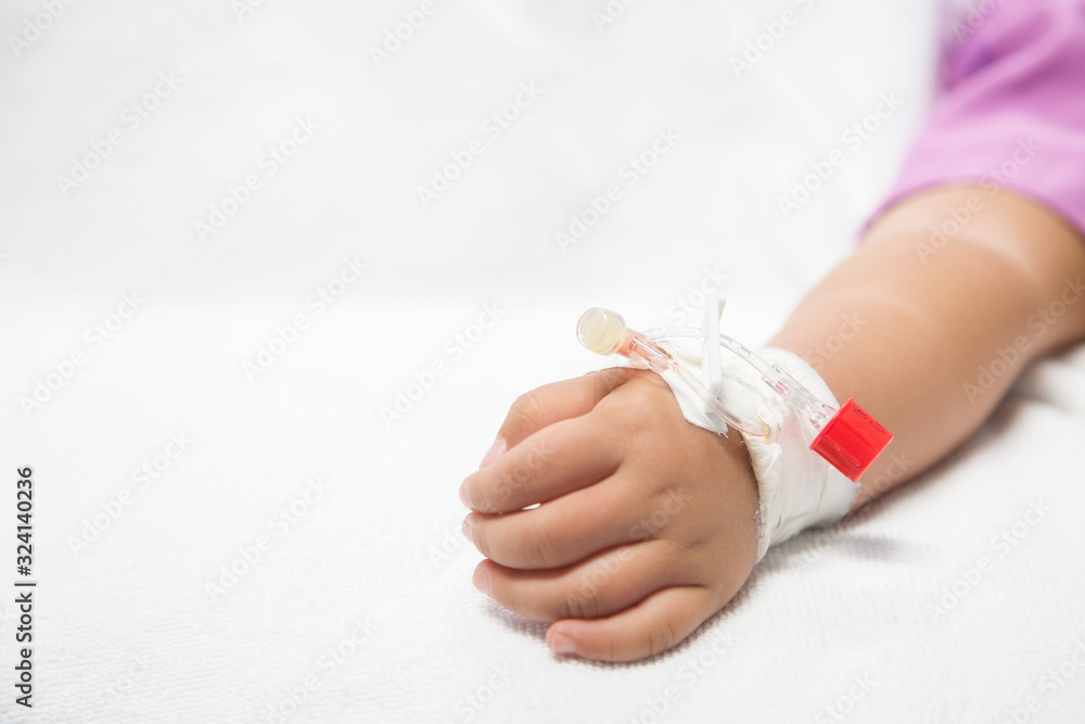 Baby hand give saline solution in bed in hospital..