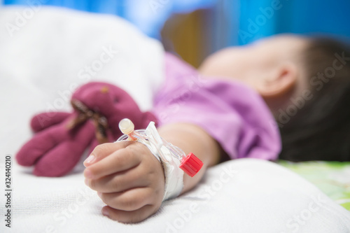 Baby hand give saline solution in bed in hospital..