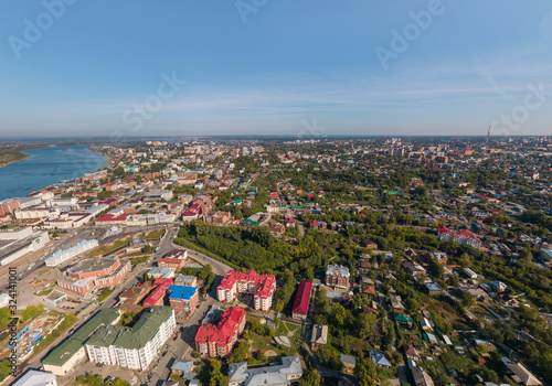 Aerial view of Tomsk city with a lot of trees and Tom river. Summer, sunny day.