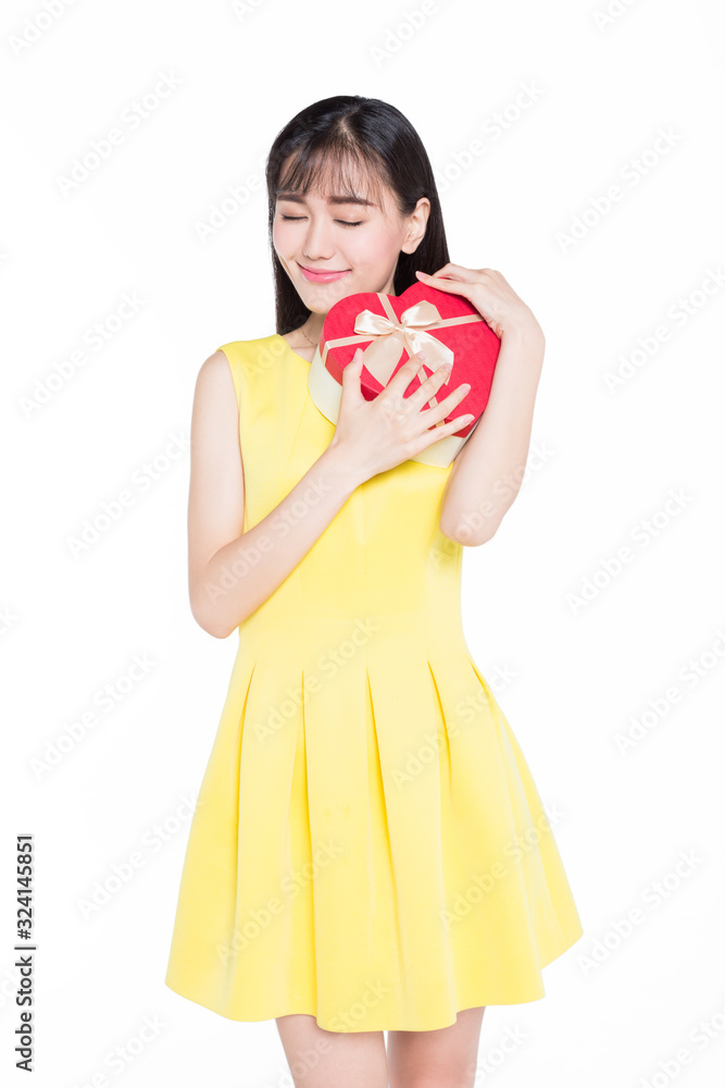 Beautiful teenage girl in yellow skirt is holding gift box Beautiful teenage girl in yellow skirt is holding gift box