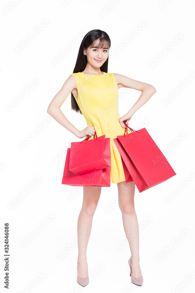 cheerful woman carrying shopping bags on white background.