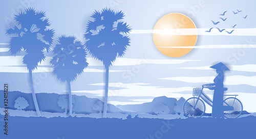 Vietnamese woman hold bicycle walk pass rice field and palm tree on sunset time