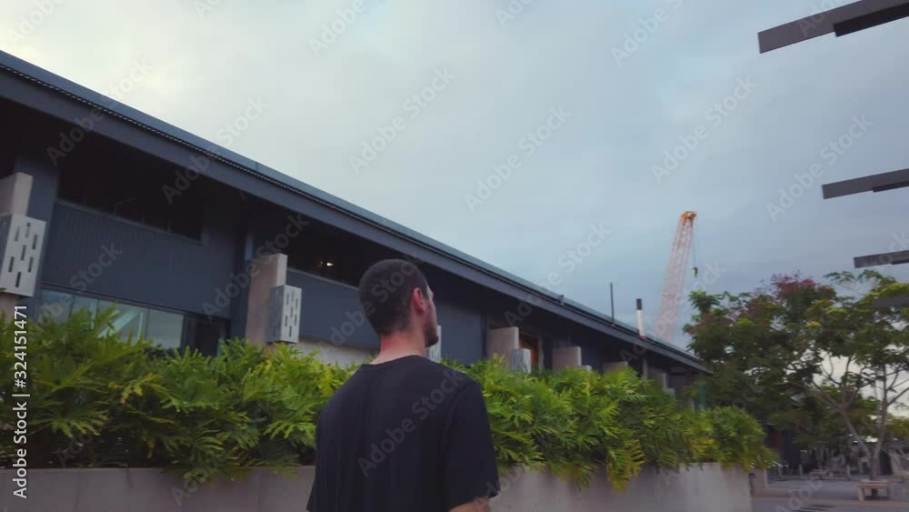 A Bearded Man Walking In The Sidewalk Wearing Black T-Shirt On A Gloomy Day - close up A Bearded Man Walking In The Sidewalk Wearing Black T-Shirt On A Gloomy Day - close up