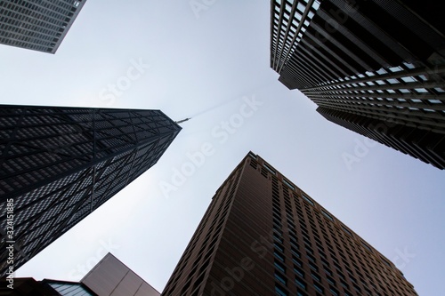 Bottom view of modern office buildings in financial district at sunset, real estate and success concept, USA