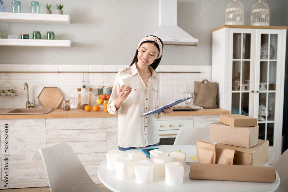 Happy young girl looking at a box in a hand. Happy young girl looking at a box in a hand.