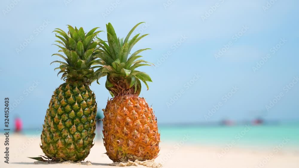 Glasses pineapples are located on the beach by the sea in the hot sun, setting the concept for summer. Glasses pineapples are located on the beach by the sea in the hot sun, setting the concept for summer.