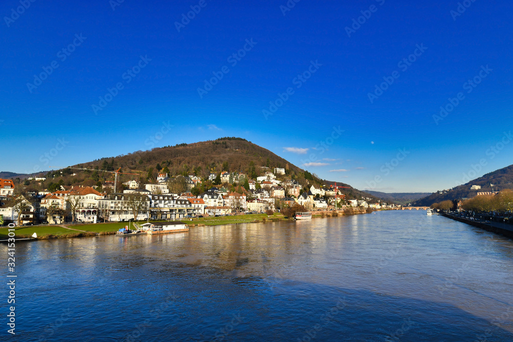 View on Odenwald forest called 'Heiligenber' with historical mansions and neckar river in city Heidelberg in Germany, view from Theodor Heuss bridge on sunny winter day