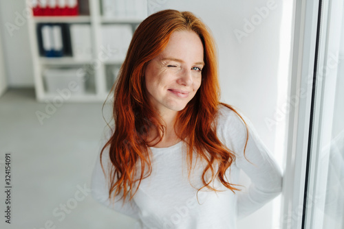 Foto Cute playful young woman winking at the camera