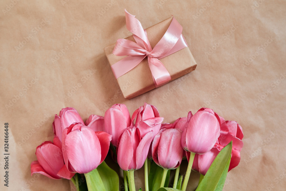 Happy woman holds tulips in her hands. Florist girl gathered a bouquet. Beautiful pink flowers. Blossom petal. Gift for the holiday celebration, springtime mood. Romantic surprise from a loved one Happy woman holds tulips in her hands. Florist girl gathered a bouquet. Beautiful pink flowers. Blossom petal. Gift for the holiday celebration, springtime mood. Romantic surprise from a loved one