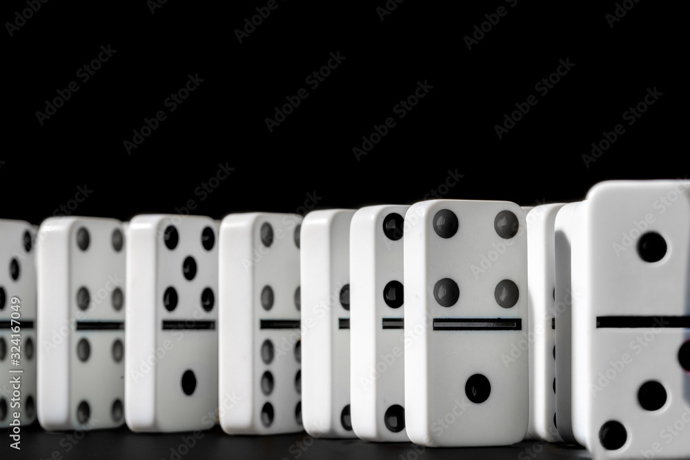 Dominoes standing in a row on black background Dominoes standing in a row on black background