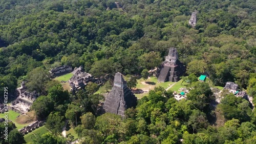 Aerial, orbit, drone shot tilting over the Tikal maya ruins, on a sunny day, in Flores, Guatemala, Central America photo