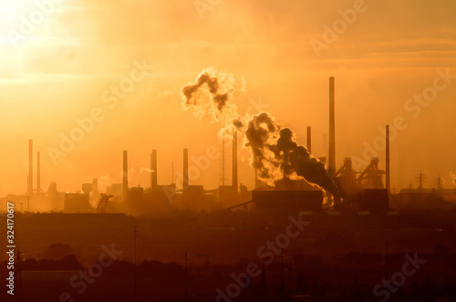 Smoke from industrial chimneys at sunset