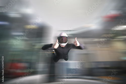 Gesticulation. Skydiver makes a gesture with his hands. A man in parachute gear.