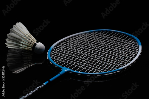 Badminton shuttlecock and badminton racket in the black background used in competition © noprati