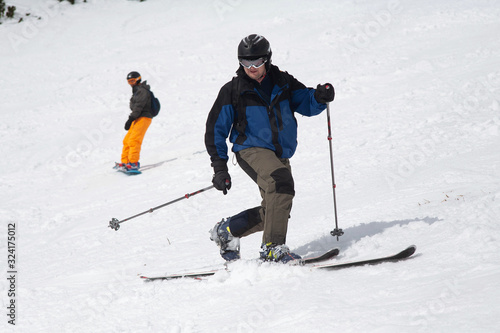 A man goes skiing on a snow-covered ski track. Ski resort. A man on snowboard. Winter sport.