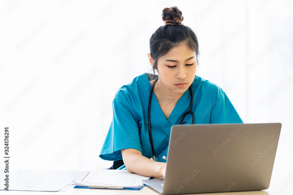 Woman Asian doctor examination and checking reports with laptop in the hospital room. Woman Asian doctor examination and checking reports with laptop in the hospital room.