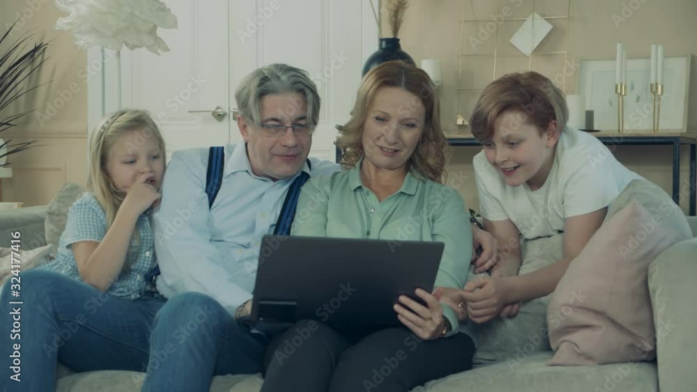 Granny and grandpa are having fun with grandkids and laptop Granny and grandpa are having fun with grandkids and laptop