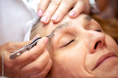 Middle aged woman getting an eyebrow treatment