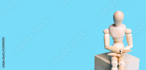 Wooden human figure on a blue background. Concept of art, creativity, courses, evolutions, minimal design