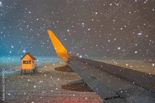airplane wing in winter under snow at night