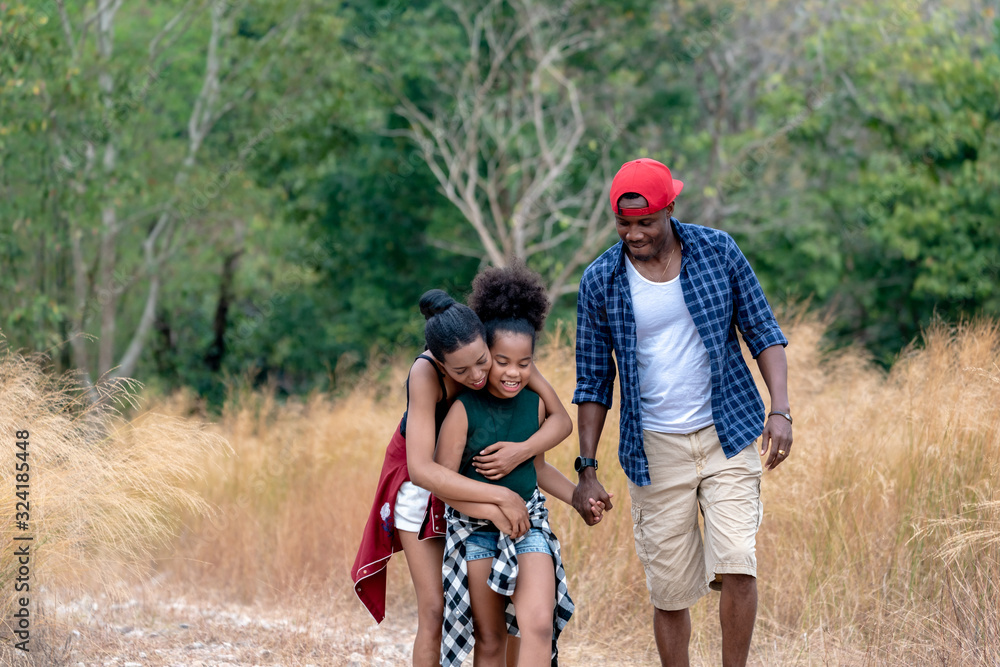 African American Family On Hiking Adventure Through Forest.