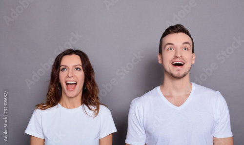 Canvas Print A surprised young couple looks up.