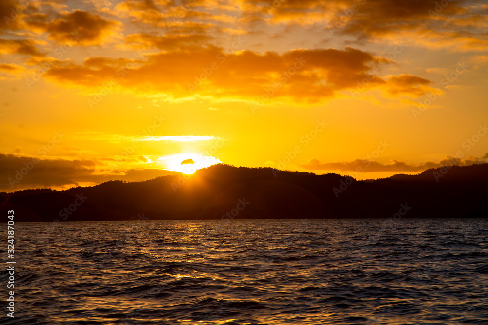 Golden sunset over the Raja Ampat islands in the Indian Ocean, West Papua, Indonesia
