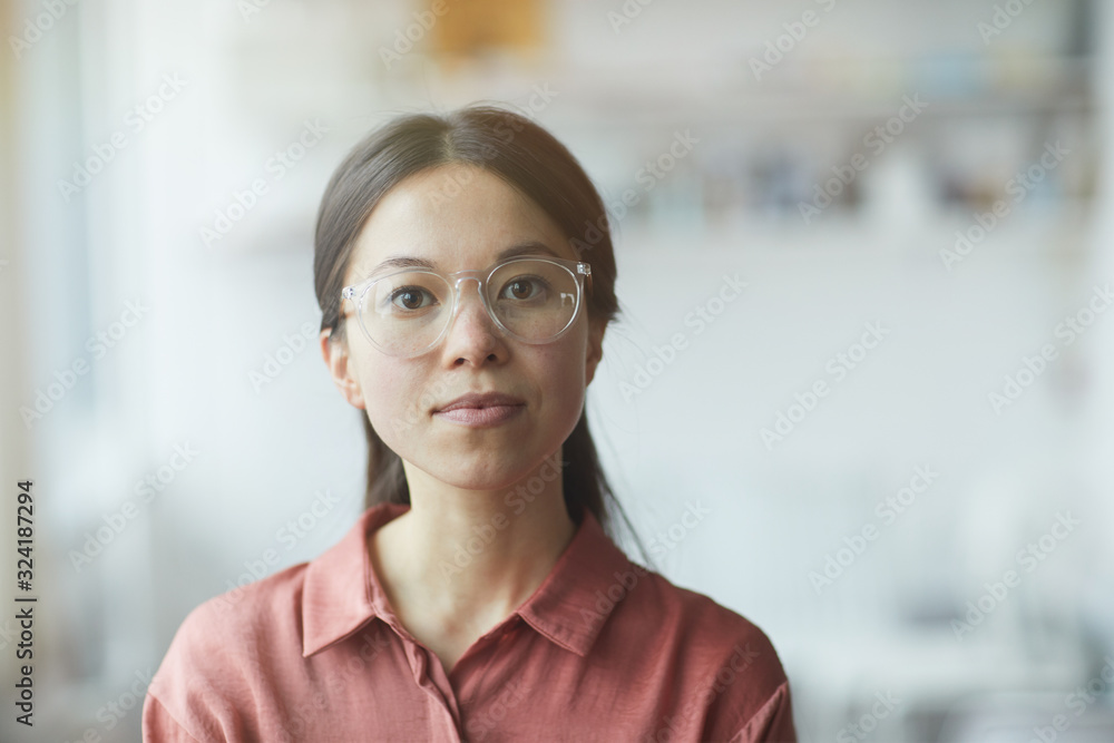 Portrait of serious young woman in eyeglasses looking at camera Portrait of serious young woman in eyeglasses looking at camera
