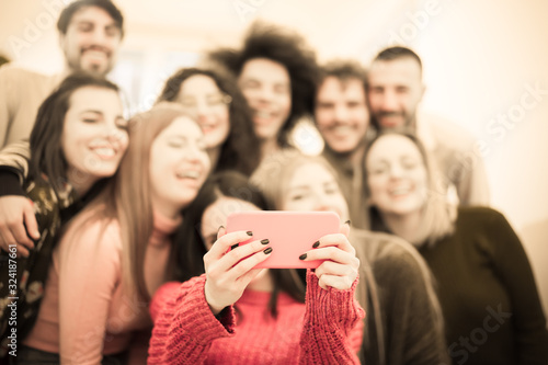 Happy friends multiracial taking selfie. Students having fun with technology trends. Youth, tech and friendship concept - Main focus on rose cellular phone - Image