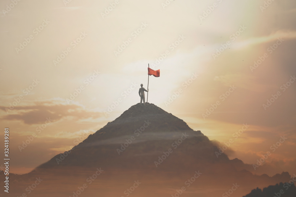 man plants his flag on the mountain peak as a sign of success