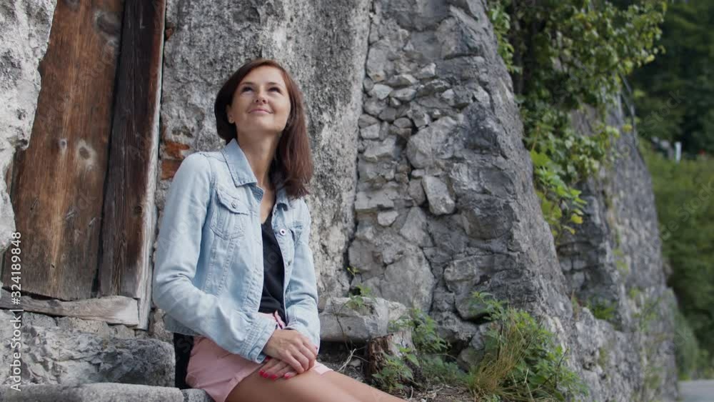woman smiles while sitting on stone steps woman smiles while sitting on stone steps