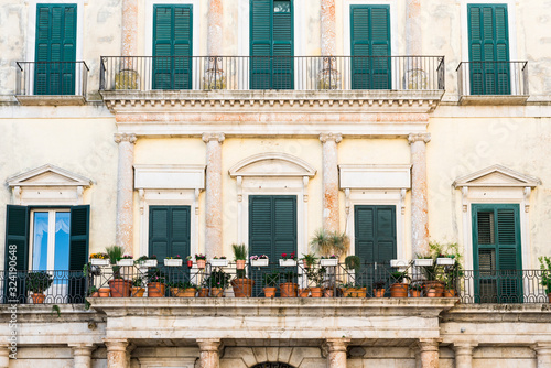 Fotografía historical building with shutters, balcony and flower pots