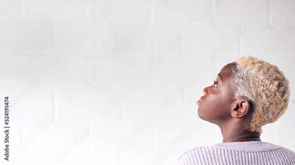 © Monkey Business - Rear View Of Young Woman Standing Against White Studio Wall