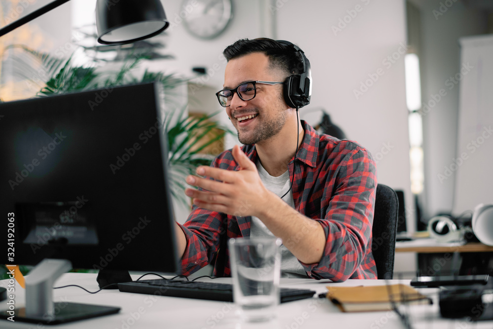 Businessman on video call. Handsome man in office with headphones.  - obrazy, fototapety, plakaty 