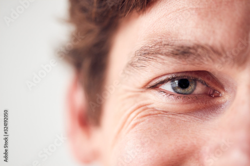 Close Up On Eyes Of Smiling Man Standing In Studio photo