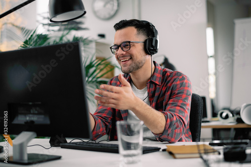 Businessman on video call. Handsome man in office with headphones.  photo