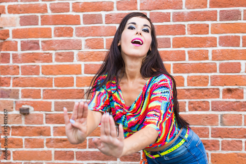 Street shaabi dance and urban dancer concept - Cheerful belly dancer dancing with arabic music on the street photo