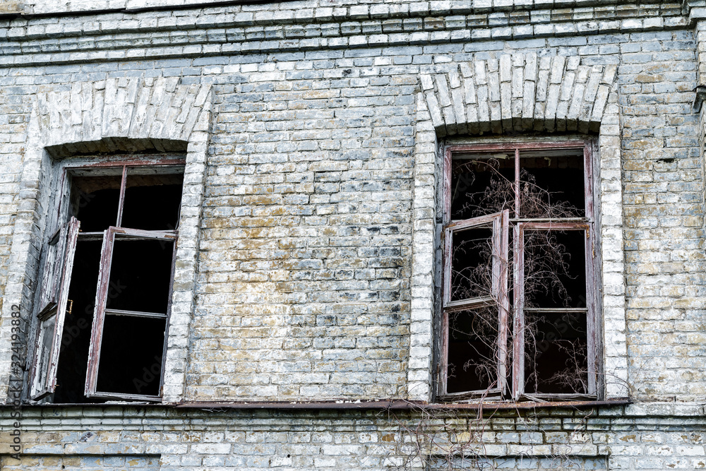 Old shabby ruined abandoned brick building wall facade with two wooden ...