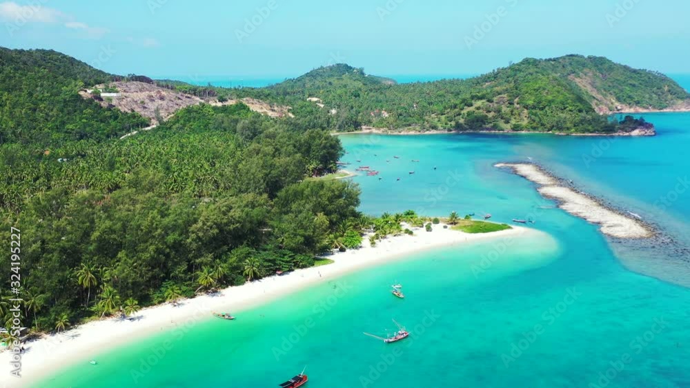 Large isthmus in the turquoise water. Thailand. Malibu beach and natural wave breaker on the tropical coast Large isthmus in the turquoise water. Thailand. Malibu beach and natural wave breaker on the tropical coast