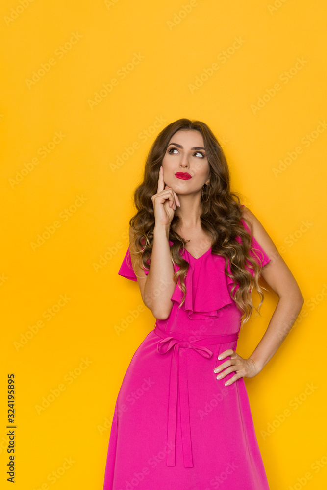 Elegant Woman In Pink Dress Is Holding Finger On Cheek, Looking Up And Thinking
