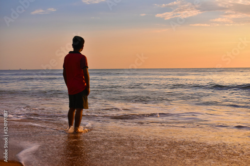 A boy standing in a beach during sunset © SUBHAJIT