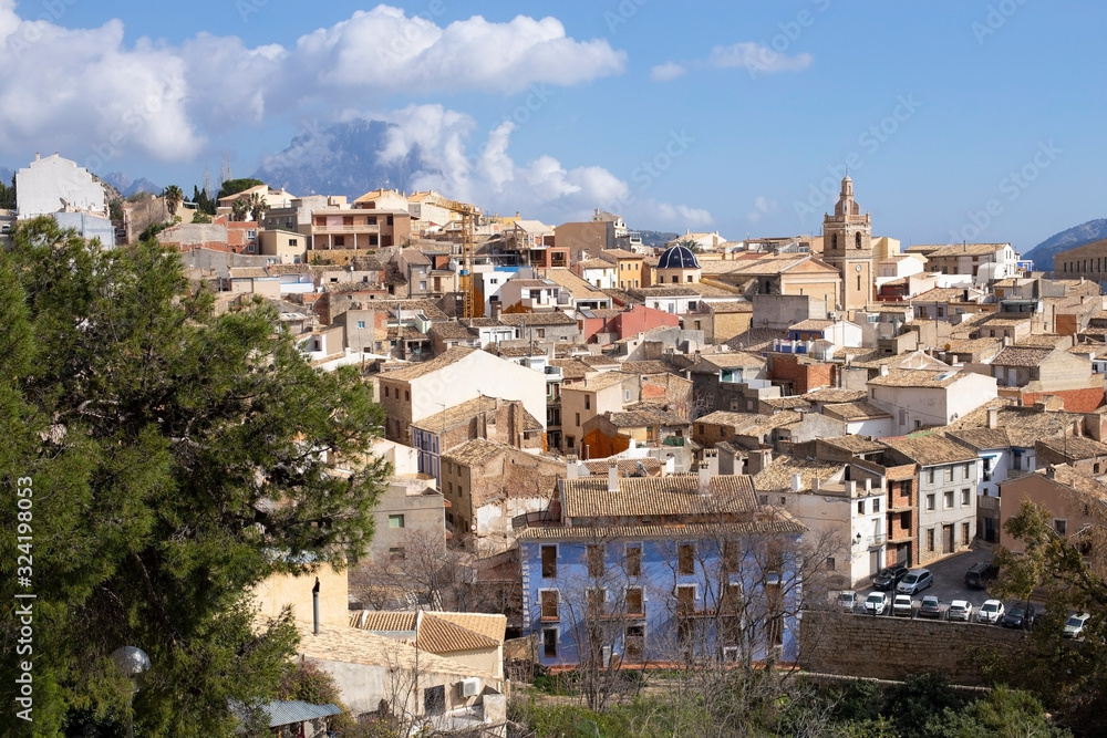 Panorama of the old town of Relleu on the Mediterranean coast in the province of Alicante, Spain, tiled roofs of the church dome and beautiful pealms